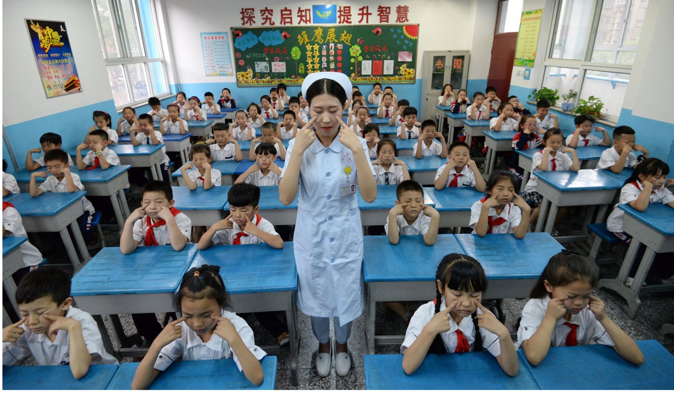 031 A hospital staff member teaches primary school children how to do eye exercises at a primary school in Handan in Chinas northern Hebei province