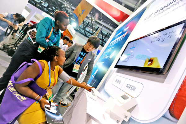 Foreign visitors experience a digital blood pressure monitor system at the China Beijing International Fair for Trade in Services