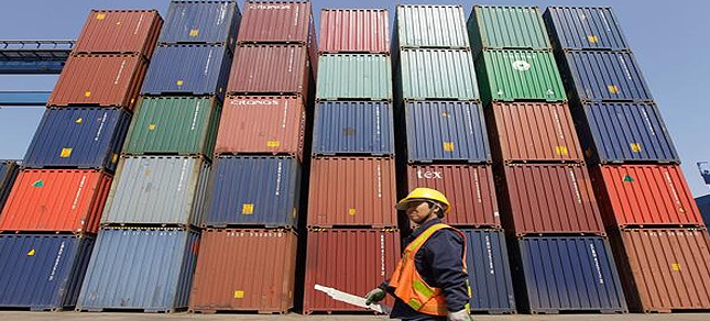 A worker walks past containers at Tianjin Port