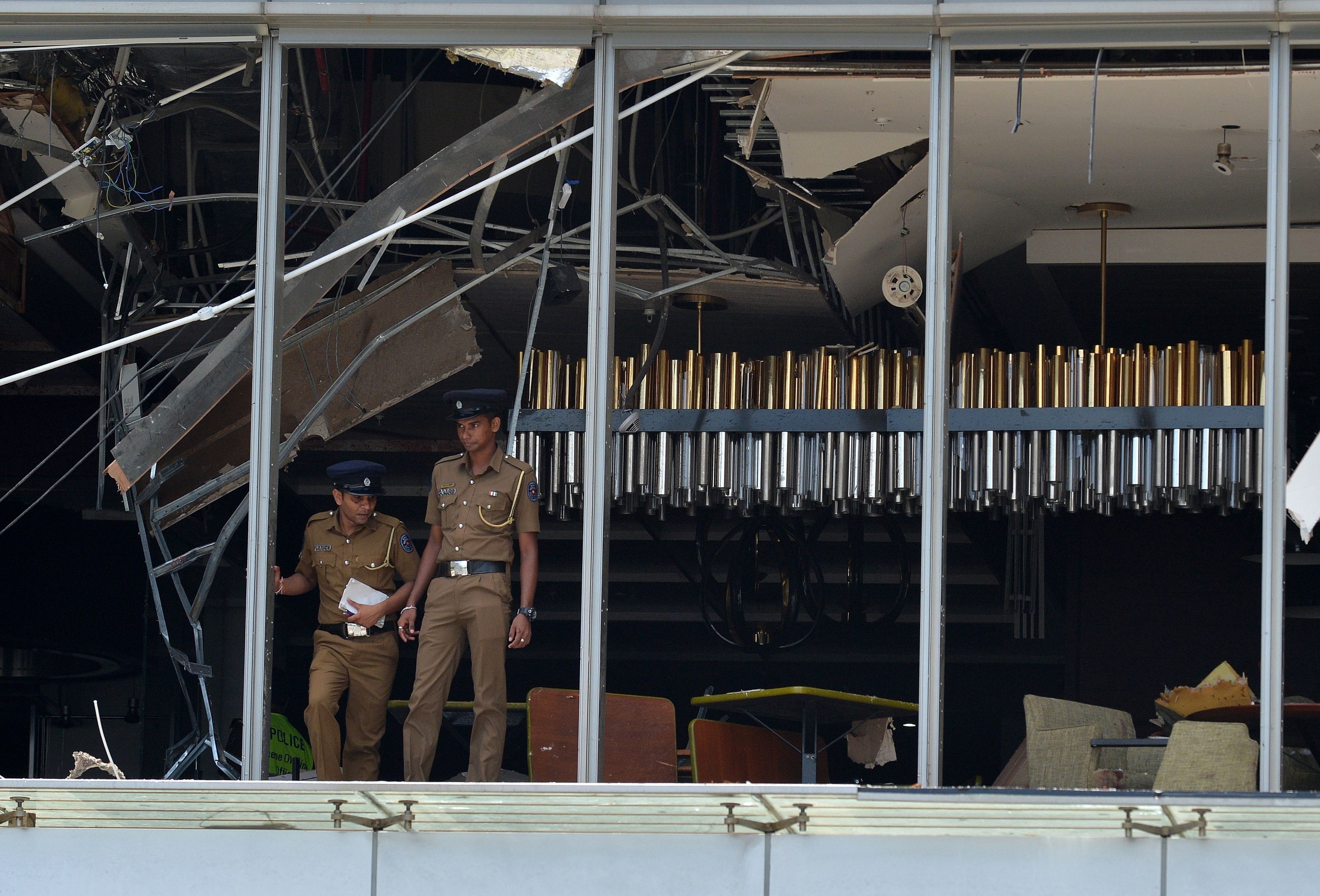 Sri Lankan police stand at the site of the explosion in a restaurant area of the luxury Shangri La Hotel in Colombo