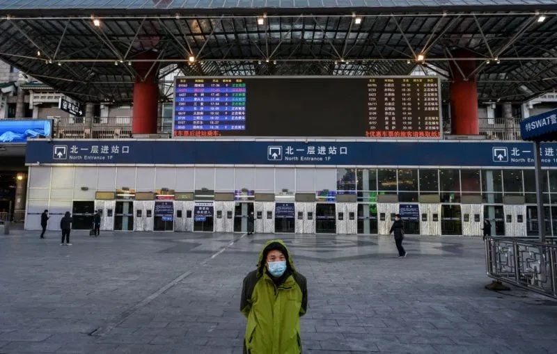 A Chinese man wears a protective mask as he stands outside a main entrance at Beijing West Railway Station as it is nearly empty on February 16 2020 in Beijing