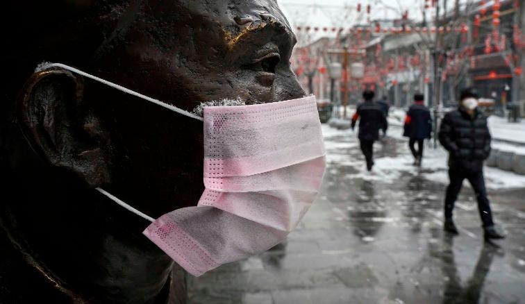 A mask is seen on a statue in Beijing