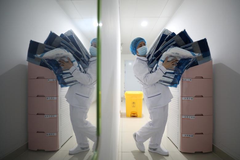 A medical worker carries protective suits at Jinyintan hospital in Wuhan