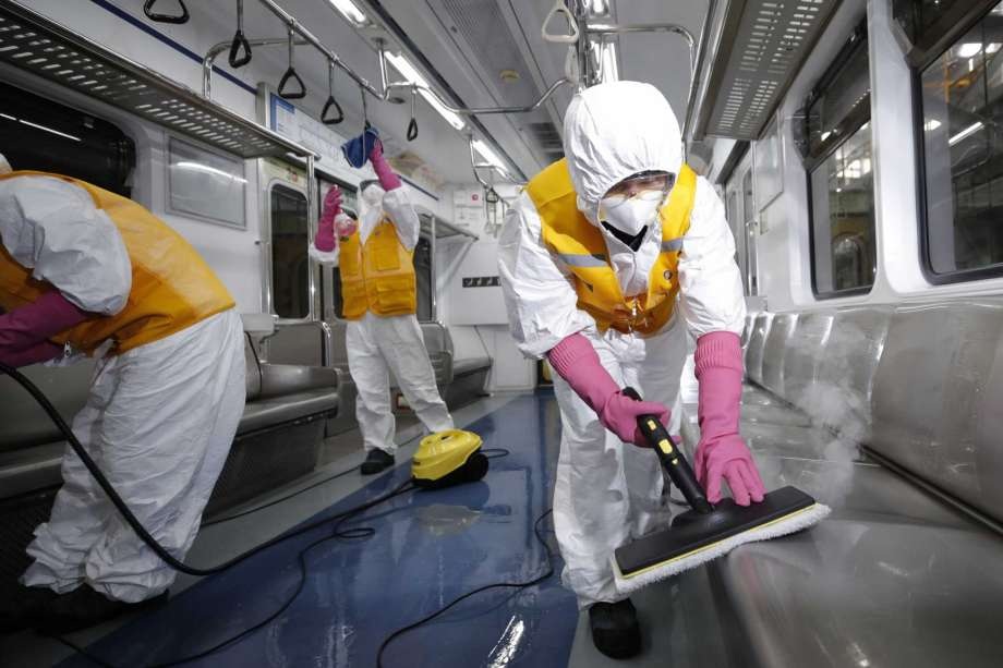 Workers wearing protective gears disinfect as a precaution against the new coronavirus at a subway car depot in Seoul South Korea