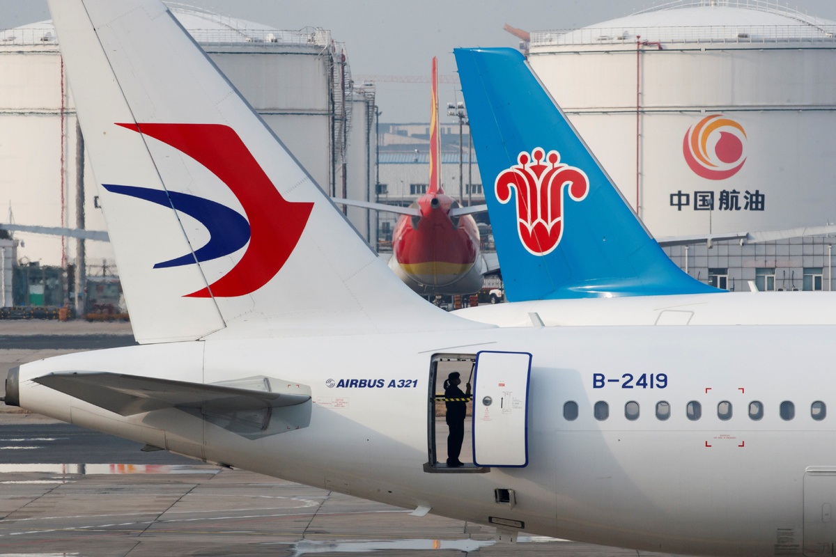 A ground staff worker cleans a parked passenger aircraft of China Eastern Airlines at Beijing Capital International Airport