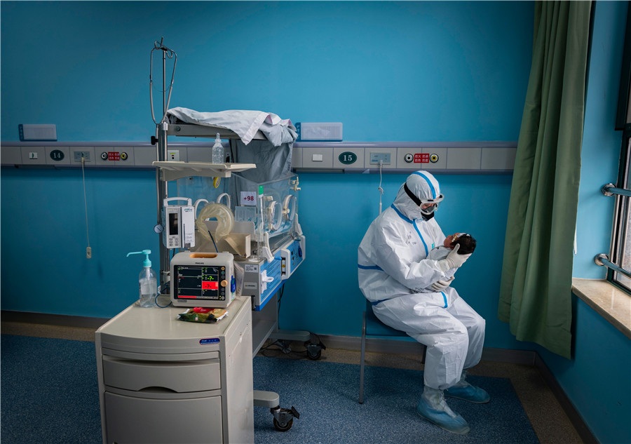 A nurse in a protective suit attends to a baby with COVID 19 in an isolation ward at Wuhan Childrens Hospital in Wuhan Hubei province on March 16