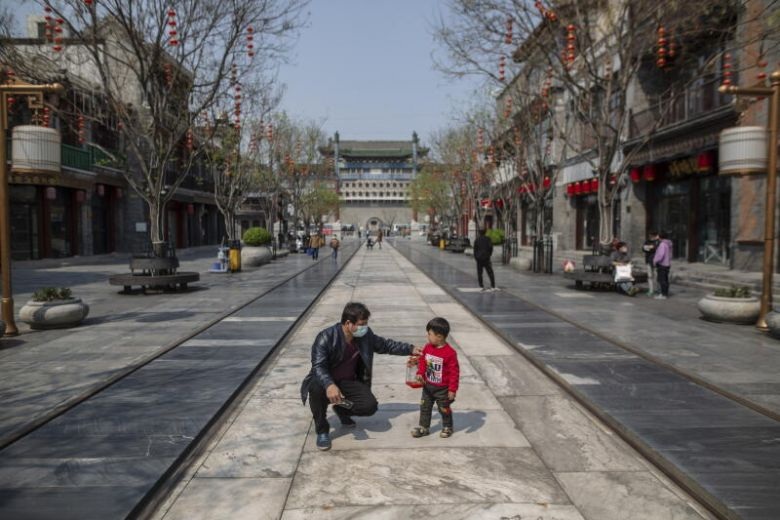 People are seen at a commercial street in Beijing on April 10