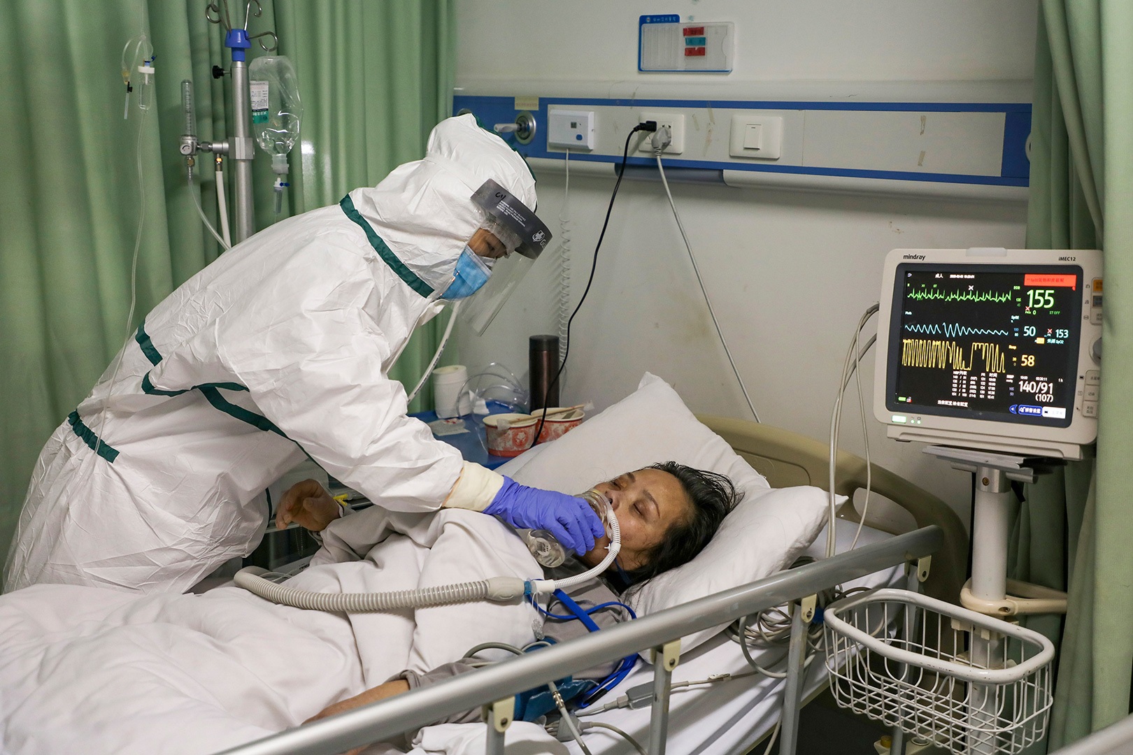 A nurse feeds water to a patient in the isolation ward for 2019 nCoV patients at a hospital in Wuhan