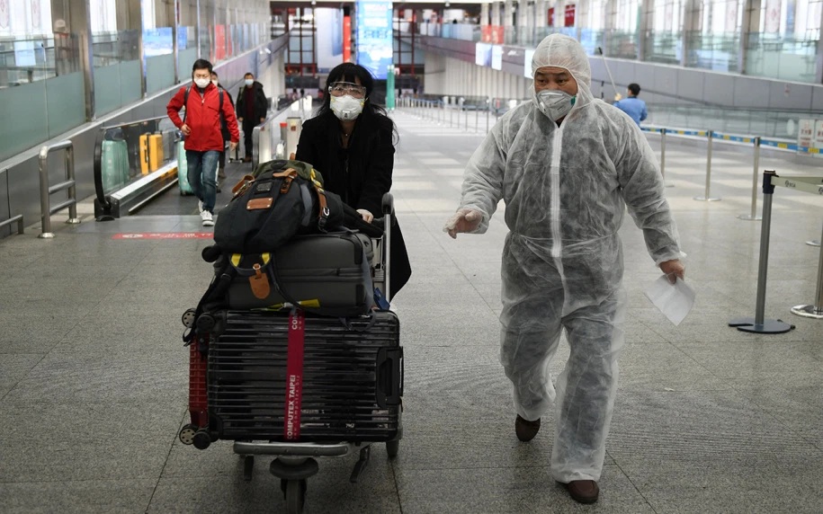 People in protective gear at Beijing Capital Airport in Beijing