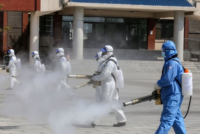 Volunteers spraying disinfectant in the compounds of a school as it prepares to reopen after the term opening was delayed due to the COVID 19 coronavirus outbreak