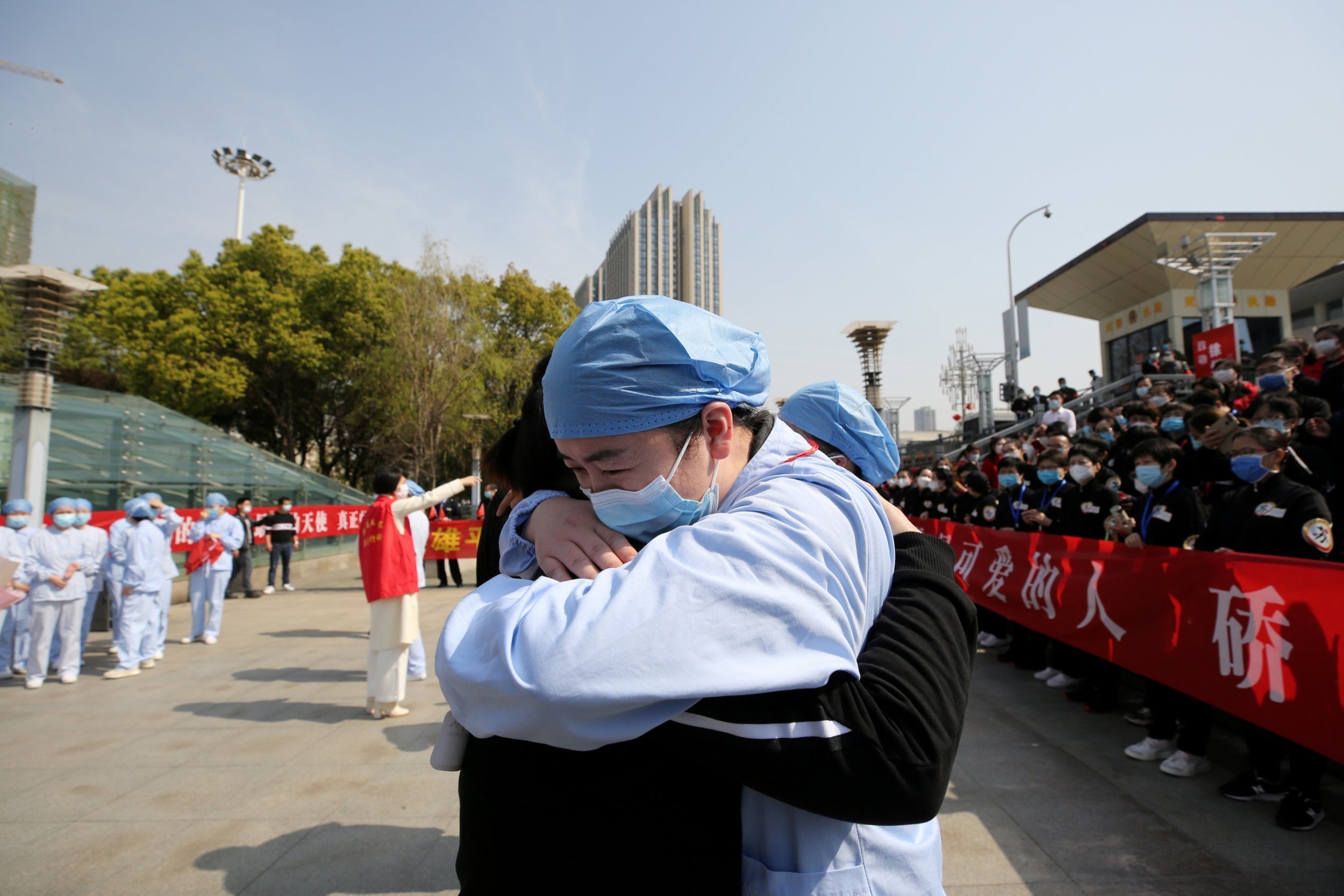 A local medical worker bids farewell to a medical worker from Jiangsu at Wuhan Railway Station as the medical team from Jiangsu leaves the city