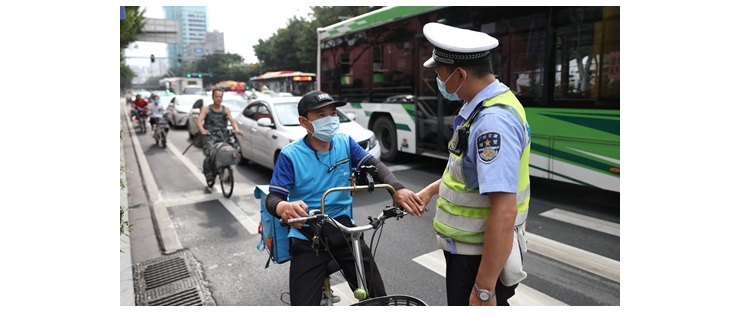 A police talks to a scooter rider who did not wear a helmet on Thursday in Guangzhou