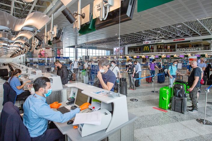 Passengers wait at Milan Malpensa International Airport on June 15