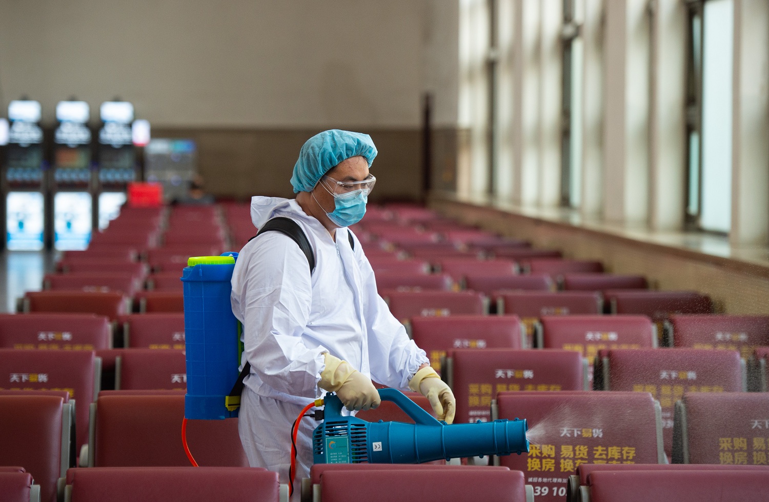 A staff member disinfects a waiting room of Beijing Railway Station in Beijing