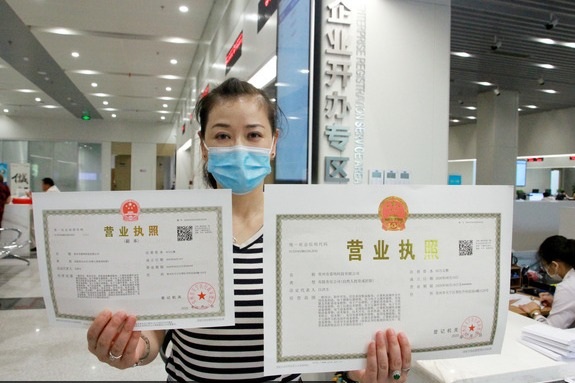 An entrepreneur shows her companys business license in Changzhou