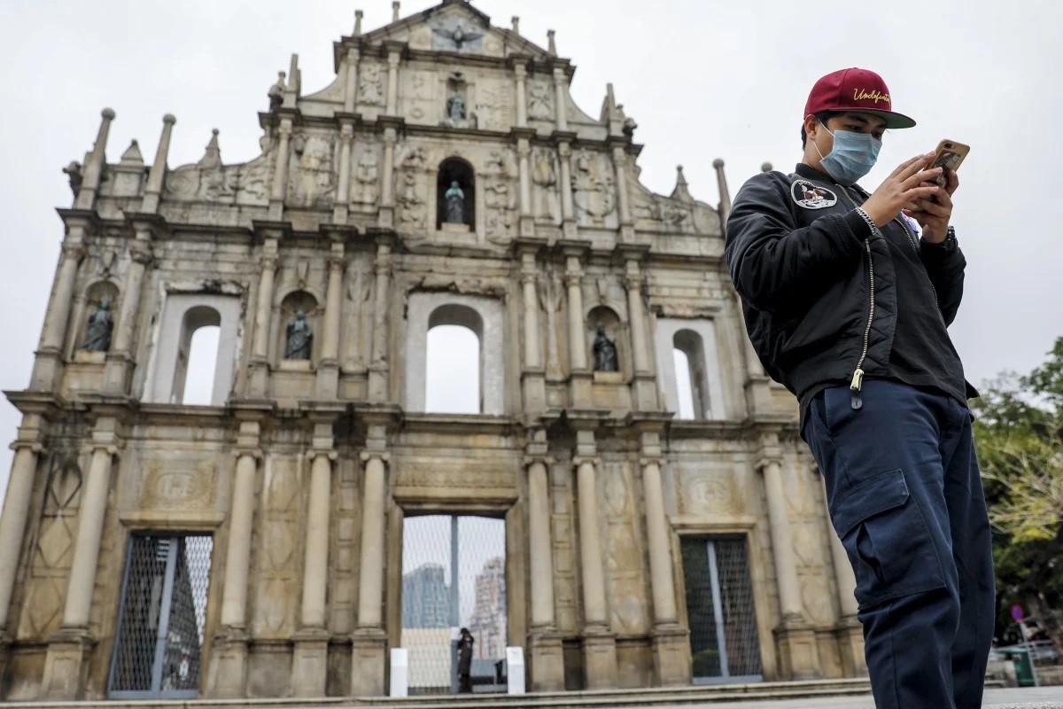 A man wearing a mask at the Ruins of St Pauls in Macau
