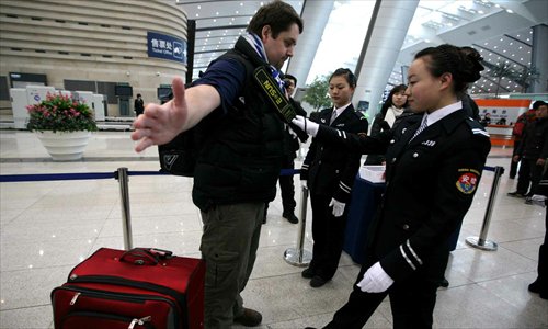 A foreigner goes through a security check in Beijing South Railway Station
