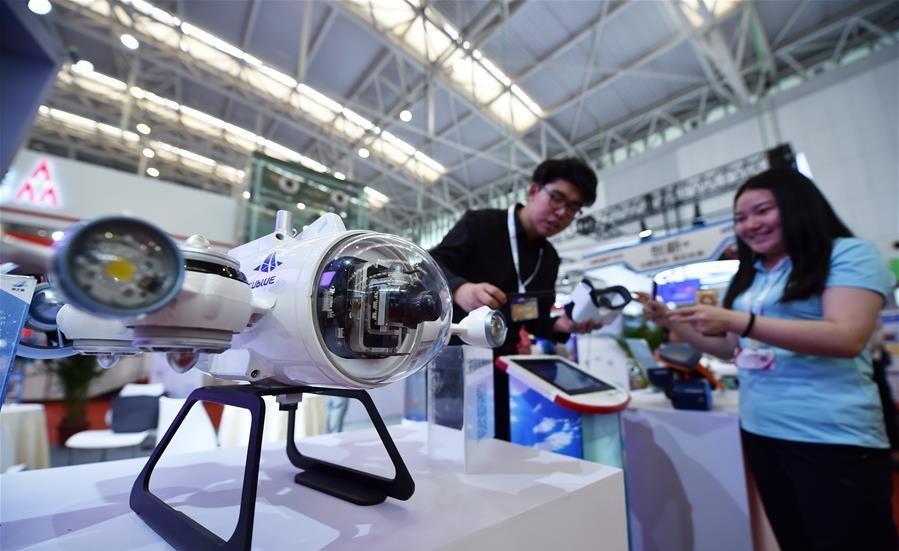 People look at an underwater robot during an intelligence science and technology exhibition in north Chinas Tianjin