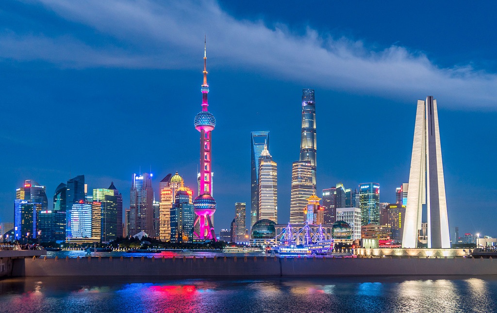 Bright colors glow and reflect on the river in this night view of the Bund in Shanghai