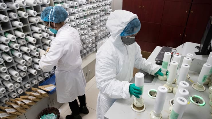 Medical personnel in protective suits prepare traditional Chinese medicine TCM for patients of the novel coronavirus with an intelligent dispensing equipment at a pharmacy of Wuhan Tongji Hospital in Wuhan