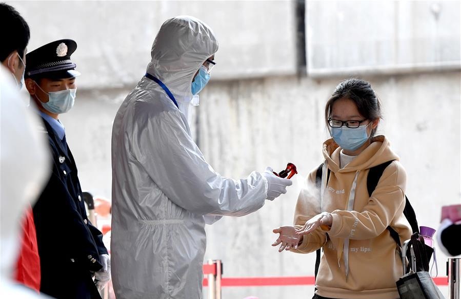 A staff member disinfects a students hands at the No. 9 Middle School in Zhengzhou central Chinas Henan Province